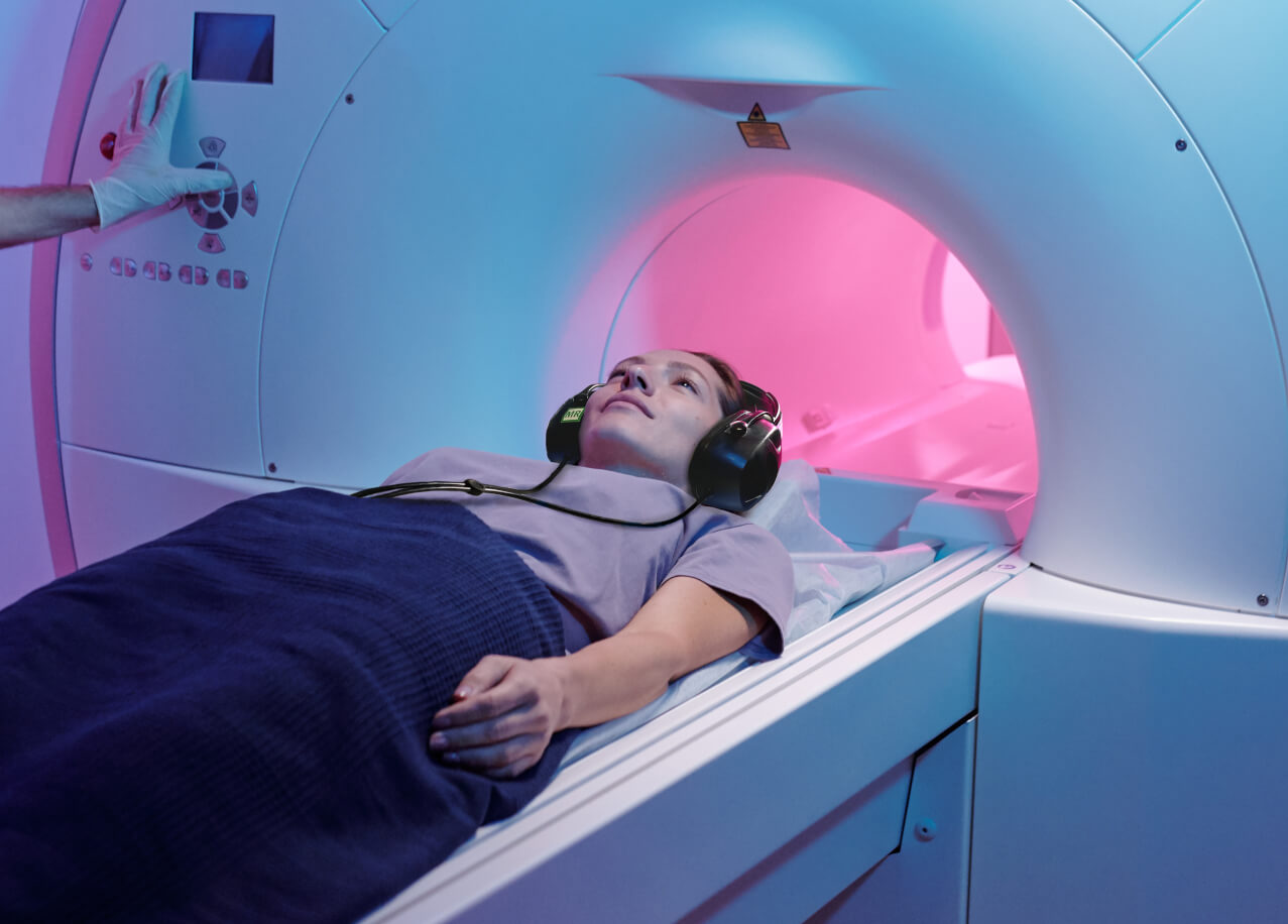 Woman about to receive an MRI scan wearing MRI compatible headphones