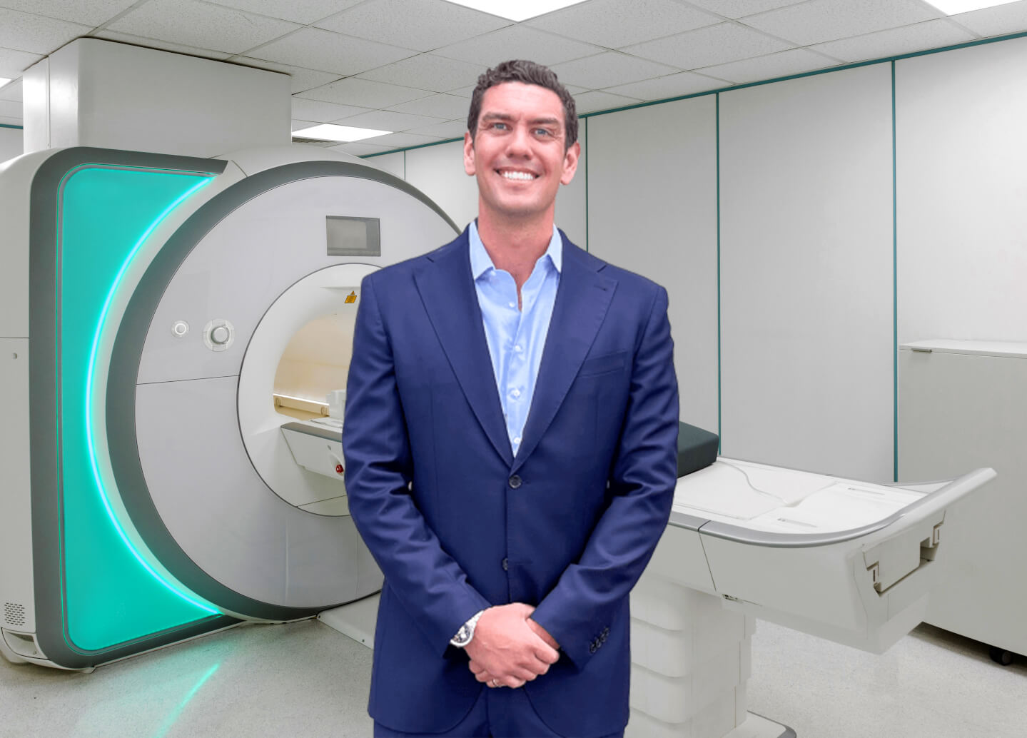 Spencer Howe standing next to an MRI machine